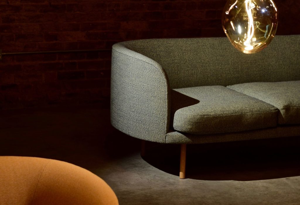 Photo of a sofa and lightbulb in a dark but modern aesthetic.